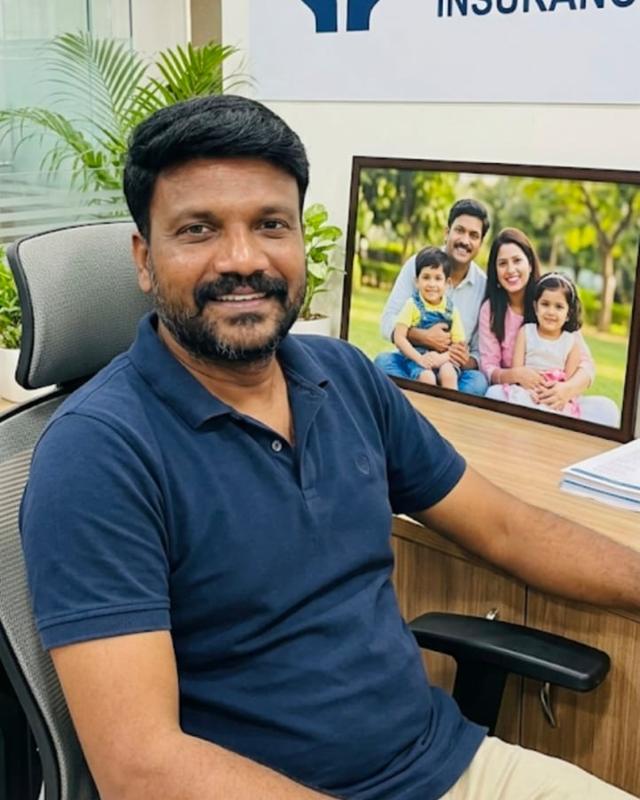 K. Naveen Kumar, insurance adviser, smiling at his office desk
